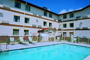 a swimming pool in front of a large building at Americas Best Value Inn St. Louis / South in Saint Louis