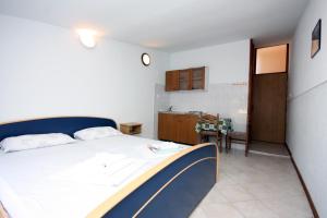 een kleine slaapkamer met een bed en een keuken bij Studio Stomorska 5239a in Stomorska