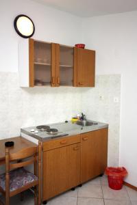 een keuken met houten kasten en een spoelbak bij Studio Stomorska 5239b in Stomorska