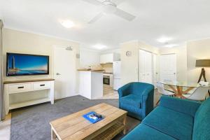 a living room with a blue couch and a table at Portobello Resort Apartments in Gold Coast