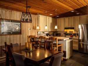 uma cozinha com uma mesa e cadeiras e um frigorífico em COZY Condo at Canyon Lodge! Sleeps 8, a walk to Canyon Lodge em Mammoth Lakes