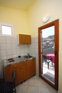 a kitchen with a sink and a door to a patio at Apartments by the sea Stomorska, Solta - 5239 in Stomorska