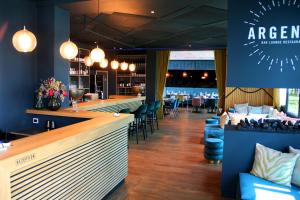a restaurant with a bar with chairs and tables at ARGENTA Living 16 in Künzell +27 photos
