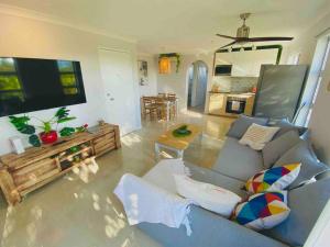 a living room with a blue couch and a tv at Broadbeach, Stylish Apartment Close To everything in Gold Coast