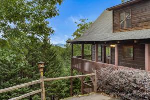 a log cabin with a porch and a wooden fence at Large Cabin with views of Beautiful NC Mountains in Murphy