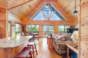 a log cabin living room with a large window at Large Cabin with views of Beautiful NC Mountains in Murphy