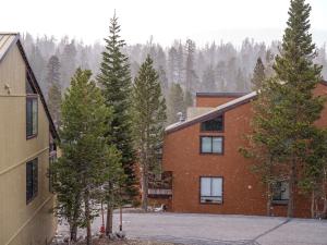 a house with trees in front of a building at COZY Condo at Canyon Lodge! Sleeps 8, a walk to Canyon Lodge in Mammoth Lakes