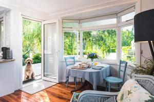 a dining room with a table and a dog looking out the door at Ranginui Retreat in Masterton