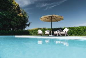 a swimming pool with an umbrella and chairs and a swimming pool at Ranginui Retreat in Masterton