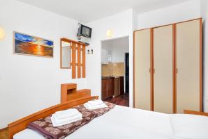 um quarto com uma cama branca e um closet em Studio Pokrivenik 5231d em Gdinj