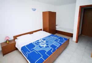 a bedroom with a bed with a blue and white bedspread at Apartments with a parking space Mimice, Omis - 5251 in Mimice +30 photos