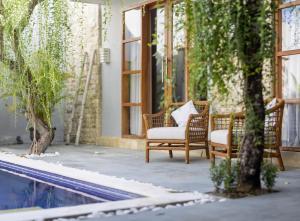 a patio with two chairs and a pool at Bali Voyage in Seminyak