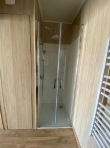 a shower with a glass door in a bathroom at Duplex atypique en bois entre ville et verdures in La Chapelle-Saint-Mesmin