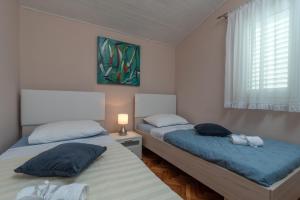 En eller flere senger på et rom på Apartments by the sea Rastici, Ciovo - 5233