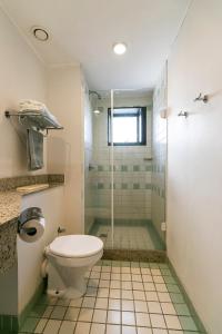 a bathroom with a toilet and a glass shower at Suíte na região dos hospitais in São Paulo
