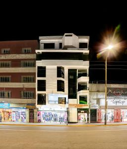 a building with a street light in front of it at Hotel Huaytapallana suites in Huancayo