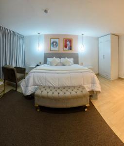 a bedroom with a large bed and a chair at Hotel Huaytapallana suites in Huancayo
