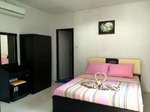 um quarto com uma cama rosa e uma cómoda em Baansanook Resort & Swimming Pool em Ko Chang