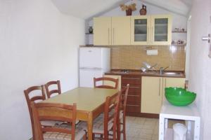 a kitchen with a table and chairs and a refrigerator at Apartments by the sea Igrane, Makarska - 5266 in Igrane