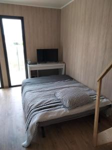 1 dormitorio con 1 cama y escritorio con TV en Gîte atypique en bois entre ville et verdures, en La Chapelle-Saint-Mesmin