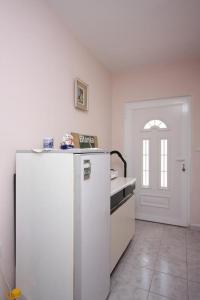 a kitchen with a white refrigerator and a door at Apartments and rooms with parking space Jezera, Murter - 5082 in Jezera