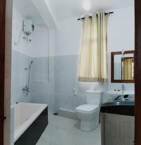 y baño con aseo, bañera y lavamanos. en Cottage 23, en Kurunegala