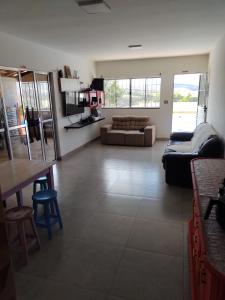 a living room with a couch and a table at POUSADA ALVE VERDe in Capitólio