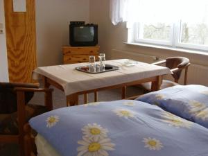 einen Tisch und Stühle mit einem Tisch und einem TV in der Unterkunft Gasthof Bergquelle in Wandlitz