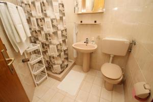een badkamer met een toilet, een wastafel en een douche bij Apartments by the sea Duce, Omis - 5275 in Dugi Rat +26 foto's