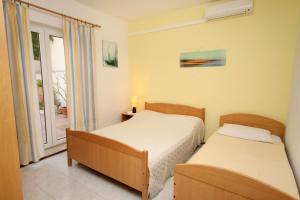 twee bedden in een kamer met een raam bij Apartments by the sea Duce, Omis - 5275 in Dugi Rat