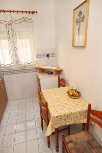 een kleine keuken met een tafel en een wastafel bij Apartments by the sea Duce, Omis - 5275 in Dugi Rat