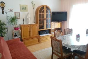 een woonkamer met een eettafel en een tv bij Apartments by the sea Duce, Omis - 5275 in Dugi Rat