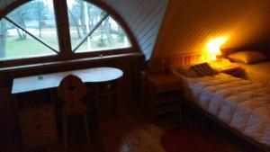 a bedroom with a bed and a table and a window at Saare Guest Apartment in Saare +3 photos