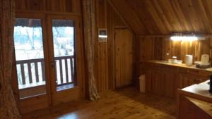 a kitchen with a large window in a log cabin at Saare Guest Apartment in Saare