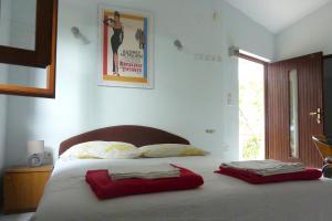 Studio Zavode 5252a في لوكفا روجوزنيكا: غرفة نوم بها سرير ووسادتين حمرا