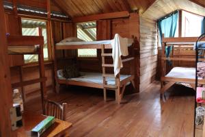 a room with several bunk beds in a cabin at Centro Ecológico Montaña Verde in Rivas