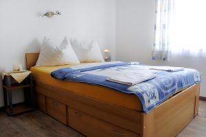 a bed with a blue blanket and white pillows at Apartments with a parking space Jadranovo, Crikvenica - 5285 in Jadranovo