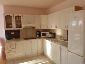 una cocina blanca con armarios blancos y fregadero en Apartments with a parking space Biograd na Moru, Biograd - 5282 en Biograd na Moru