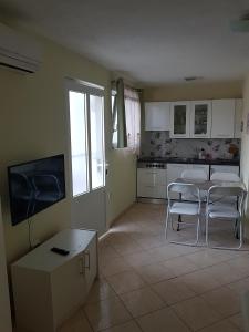 kuchnia z dwoma krzesłami, stołem i telewizorem w obiekcie Apartment Biograd na Moru 5282c w Biogradzie na Moru