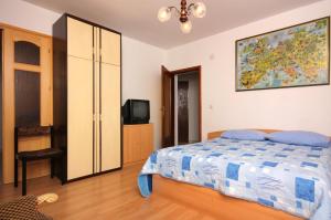 a bedroom with a bed and a tv in it at Apartment Vrbnik 5301b in Vrbnik