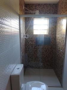 a bathroom with a glass shower with a toilet at POUSADA ALVE VERDe in Capitólio +27 photos