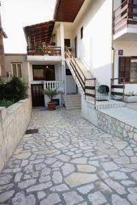 a house with a stone walkway in front of a building at Double Room Vrbnik 5301b in Vrbnik