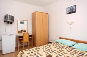 um quarto com uma cama, uma secretária e um armário em Double Room Vrbnik 5301b em Vrbnik