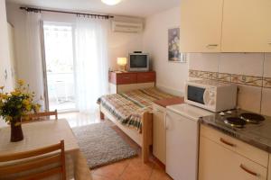 a small room with a bed and a kitchen at Apartments with a parking space Malinska (Krk) - 5289 in Malinska