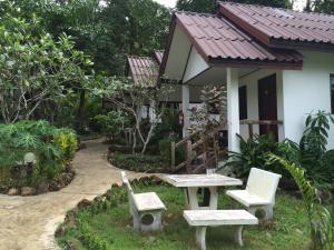 チャン島にあるBaansanook Resort & Swimming Poolのテーブルと椅子が前にある家