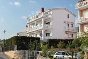 a white house with a car parked in front of it at Apartments with a parking space Selce, Crikvenica - 5287 in Selce