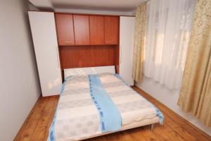 a small bedroom with a bed and a window at Apartments with a parking space Selce, Crikvenica - 5287 in Selce