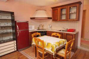 a kitchen with a table with chairs and a refrigerator at Apartments with a parking space Selce, Crikvenica - 5287 in Selce