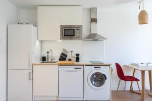 a white kitchen with a washing machine and a table at La Palmeraie - Splendide coeur du Centre-Ville in Marseille