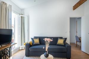 a living room with a blue couch and a tv at La Palmeraie - Splendide coeur du Centre-Ville in Marseille